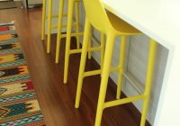 Countertop warna putih dengan kerusi kuning hiasan dapur