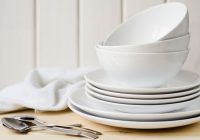 34588783 – white large and small plates and bowls on a light table